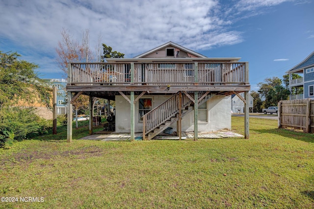 rear view of house with a wooden deck and a lawn