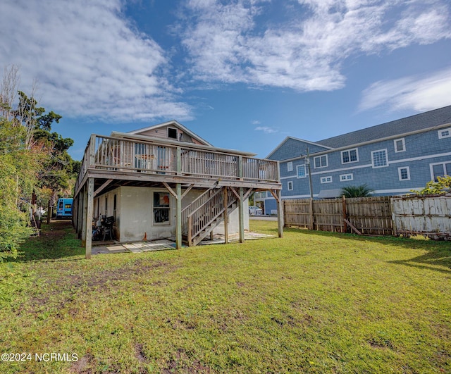 rear view of house with a wooden deck and a lawn