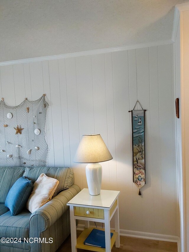 sitting room featuring ornamental molding and wood-type flooring