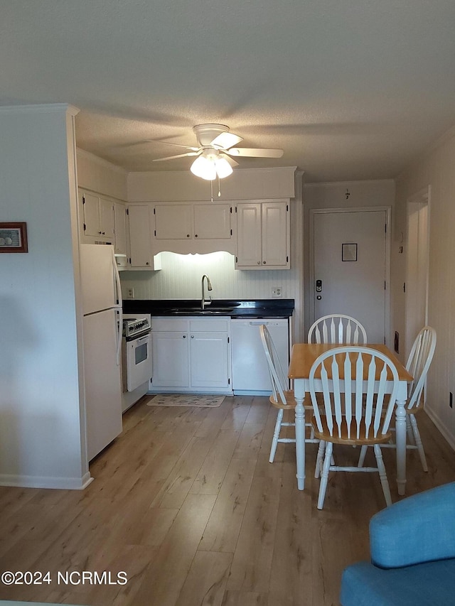 kitchen featuring white appliances, sink, white cabinetry, decorative backsplash, and light hardwood / wood-style flooring