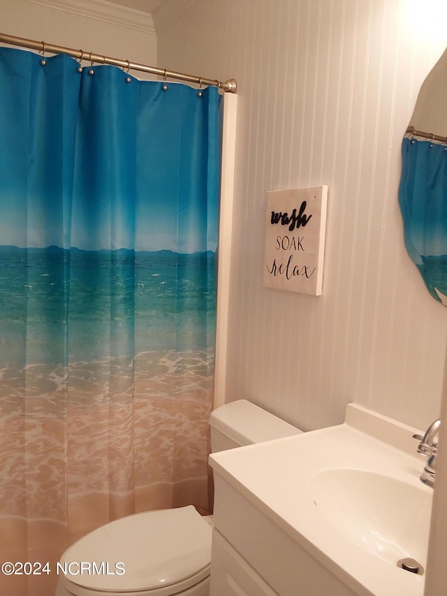 bathroom featuring vanity, toilet, ornamental molding, and walk in shower