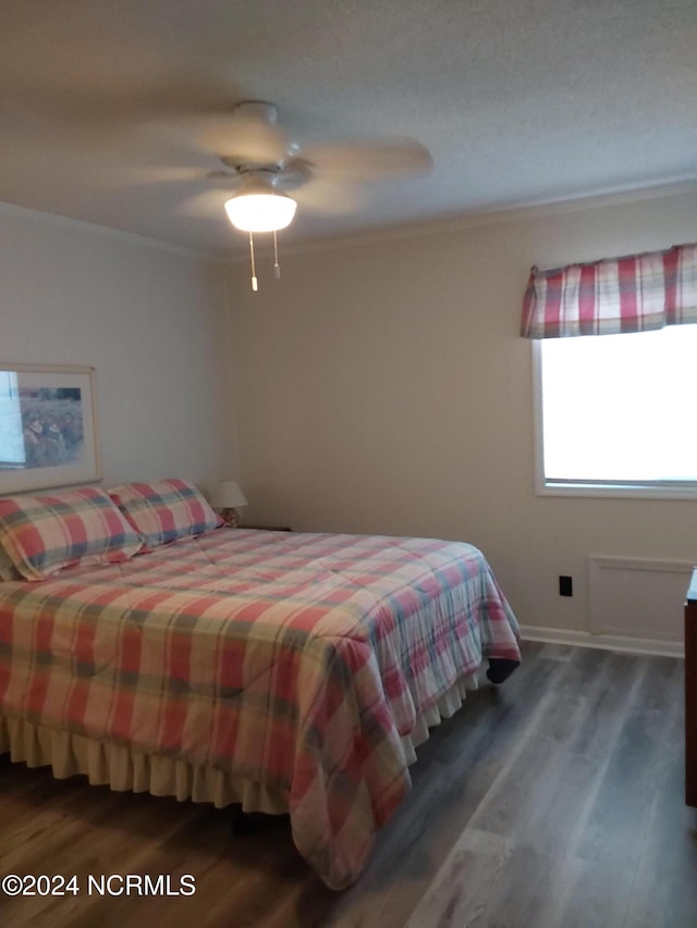 bedroom with ceiling fan, crown molding, and dark hardwood / wood-style floors