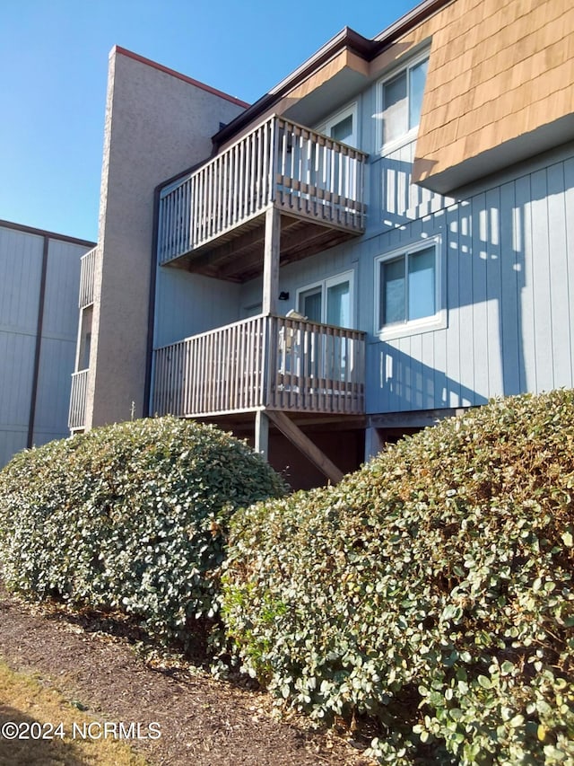 view of home's exterior with a balcony and a wooden deck