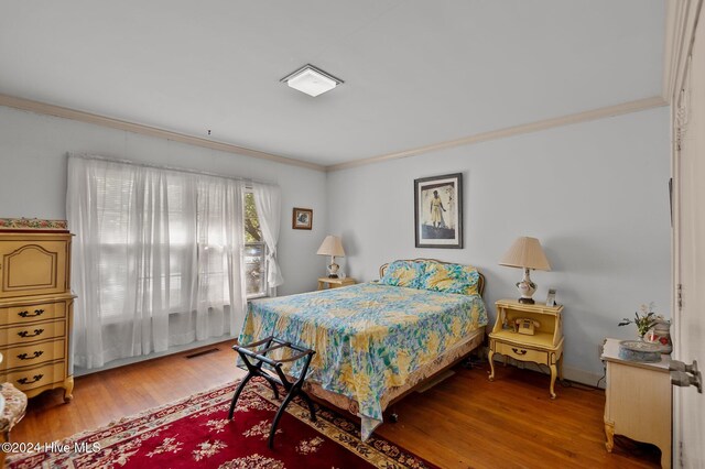 bedroom with hardwood / wood-style flooring and ornamental molding