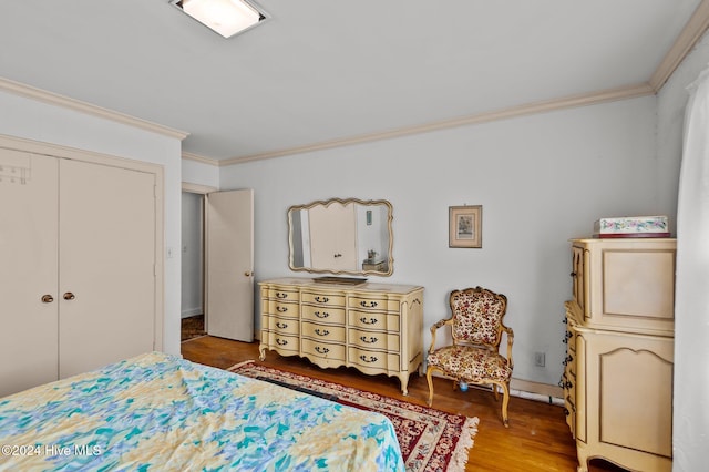 bedroom featuring a closet, ornamental molding, and wood-type flooring