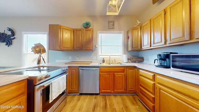 kitchen featuring sink, appliances with stainless steel finishes, light hardwood / wood-style flooring, and a healthy amount of sunlight