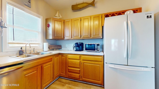 kitchen with light hardwood / wood-style floors, stainless steel appliances, and sink