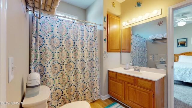 bathroom with a shower with shower curtain, toilet, ceiling fan, vanity, and hardwood / wood-style flooring