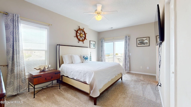 carpeted bedroom with access to exterior, multiple windows, and ceiling fan