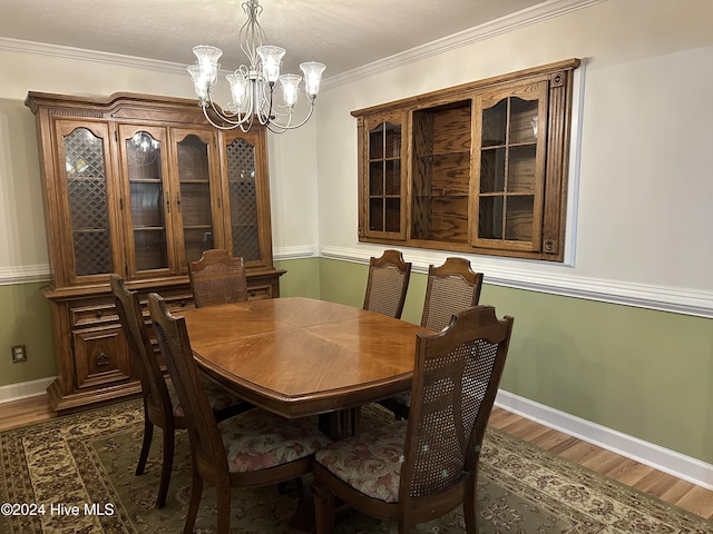 dining room with a chandelier, crown molding, and dark hardwood / wood-style floors