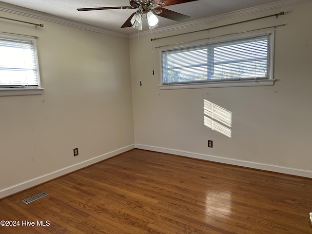 spare room featuring hardwood / wood-style flooring, ornamental molding, a textured ceiling, and ceiling fan