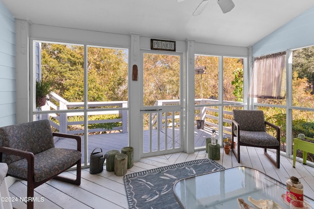 sunroom with ceiling fan, a healthy amount of sunlight, and vaulted ceiling