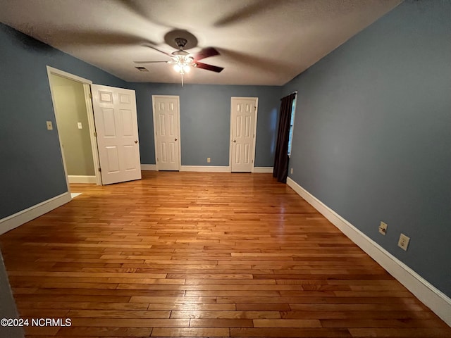 unfurnished bedroom with ceiling fan and light hardwood / wood-style flooring