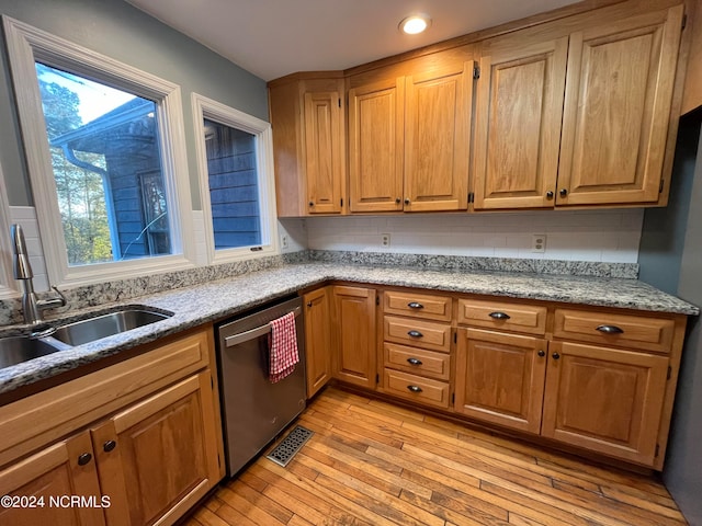 kitchen featuring plenty of natural light, light wood-type flooring, sink, and stainless steel dishwasher