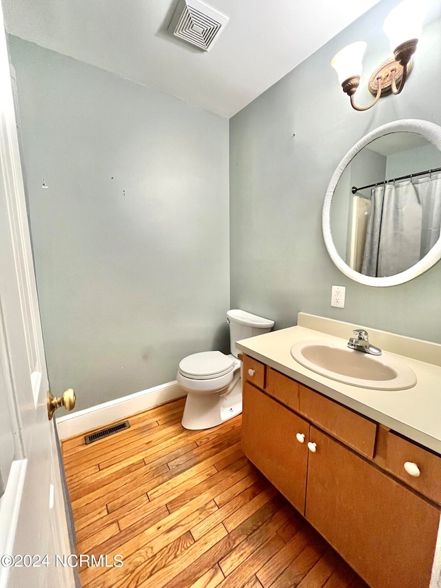 bathroom featuring vanity, hardwood / wood-style floors, and toilet