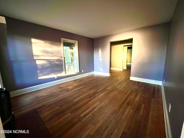 empty room with dark wood-type flooring