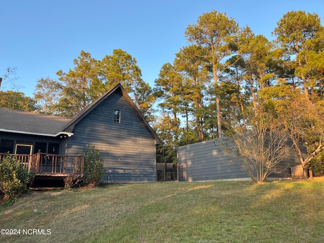 view of home's exterior featuring a wooden deck and a lawn