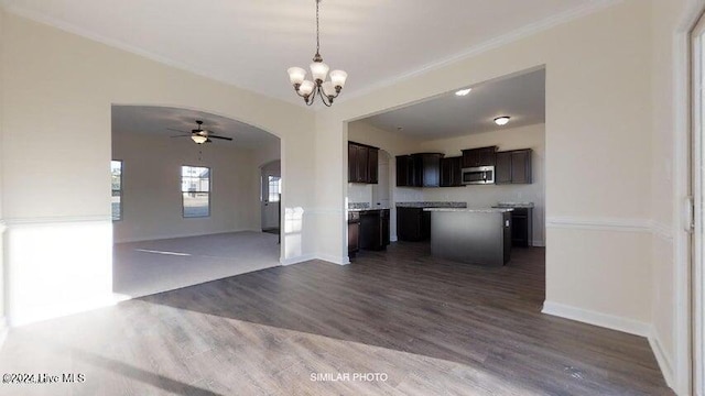 kitchen featuring ceiling fan with notable chandelier, crown molding, a center island, dark hardwood / wood-style floors, and hanging light fixtures