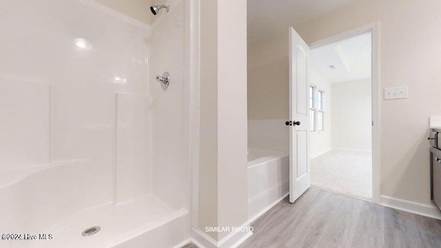 bathroom with a shower, vanity, and hardwood / wood-style flooring