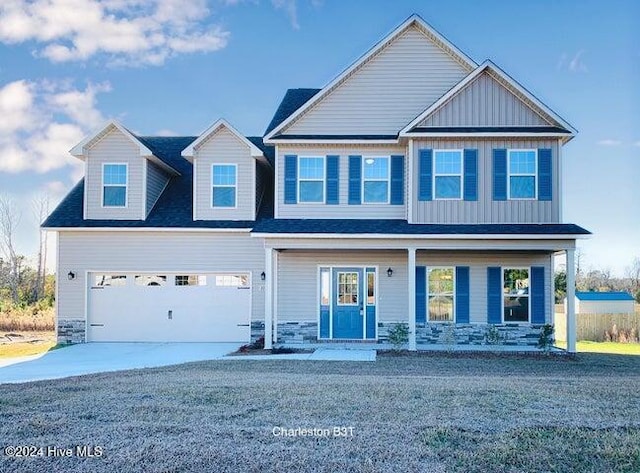 view of front of house featuring covered porch, a front yard, and a garage