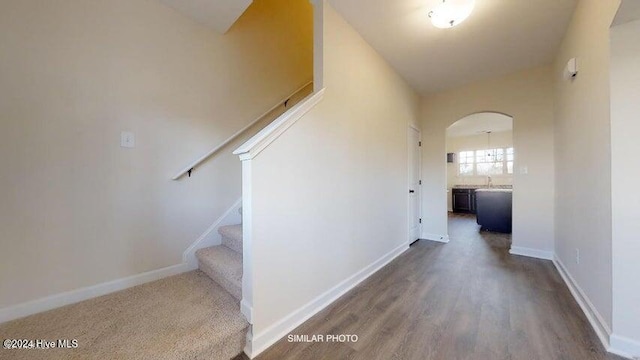 stairway with hardwood / wood-style floors and lofted ceiling