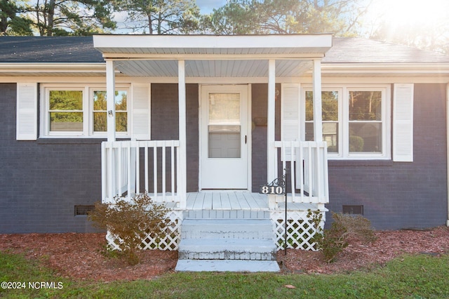 ranch-style house featuring a porch and a front lawn