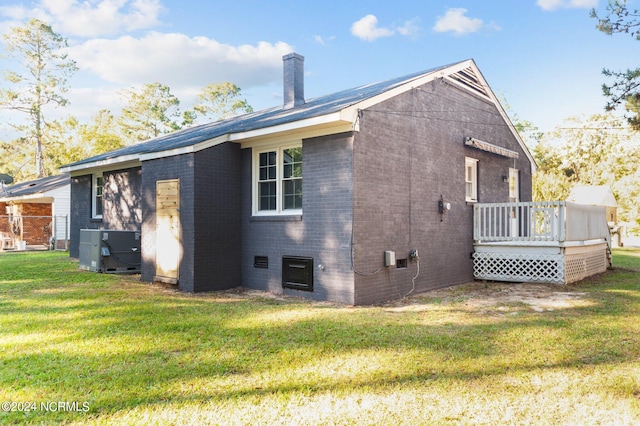 back of property with central air condition unit and a yard