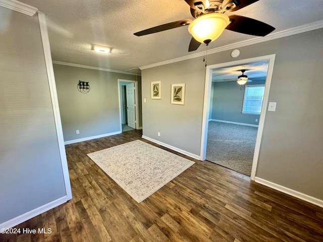 unfurnished room featuring dark hardwood / wood-style floors, ceiling fan, crown molding, and a textured ceiling