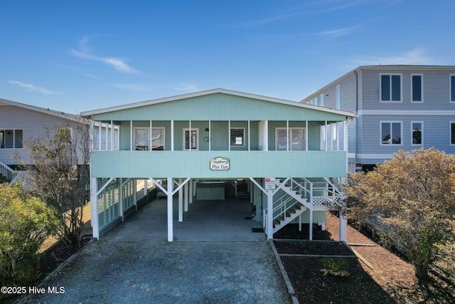 beach home with a carport, driveway, and stairway