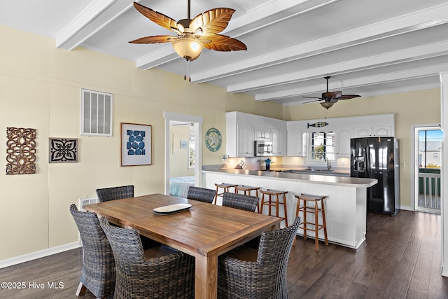 dining area featuring beam ceiling, dark wood-style flooring, visible vents, and baseboards