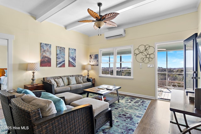 living area with beam ceiling, a ceiling fan, an AC wall unit, wood finished floors, and baseboards