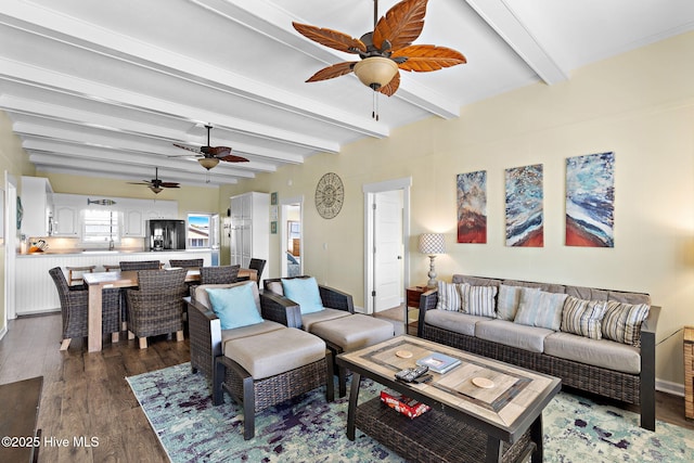 living area with beamed ceiling, dark wood finished floors, and a ceiling fan