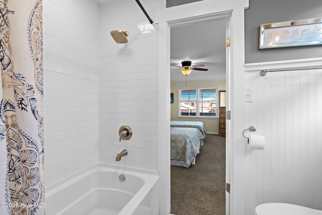 ensuite bathroom with a ceiling fan, connected bathroom, toilet, a wainscoted wall, and shower / bathtub combination with curtain