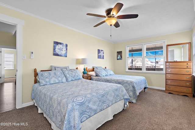 carpeted bedroom featuring ornamental molding, multiple windows, and baseboards