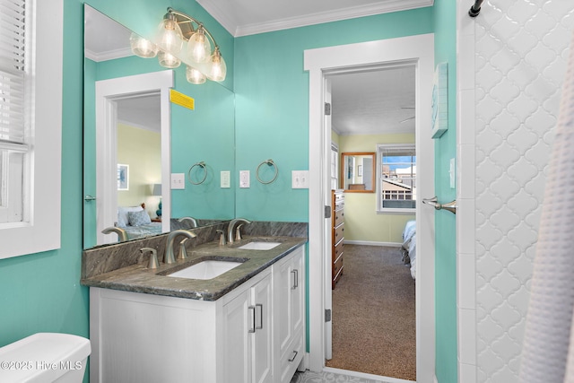 ensuite bathroom with double vanity, crown molding, a sink, and ensuite bathroom