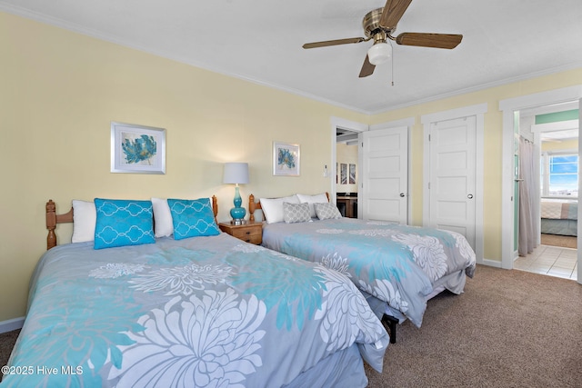 carpeted bedroom with a ceiling fan, crown molding, and baseboards