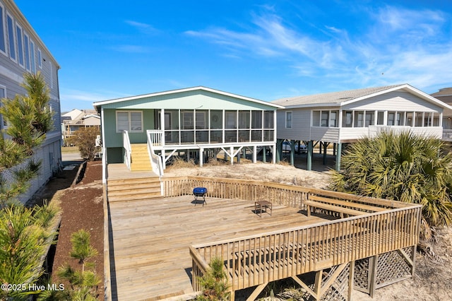 back of property with a sunroom and a wooden deck