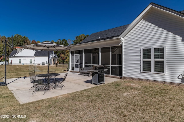 rear view of house featuring a yard, a patio, and a sunroom