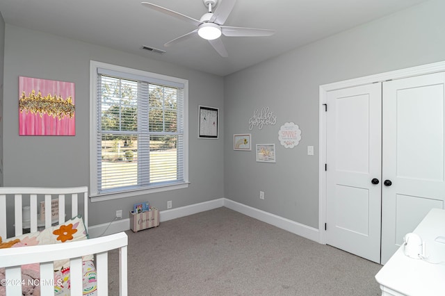 bedroom with ceiling fan, light colored carpet, and a closet