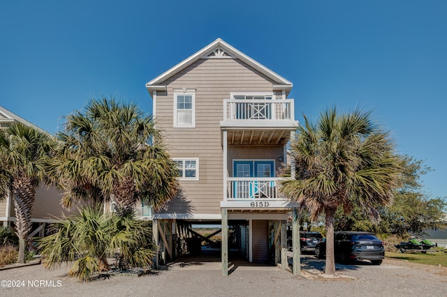 back of property featuring a balcony and a carport