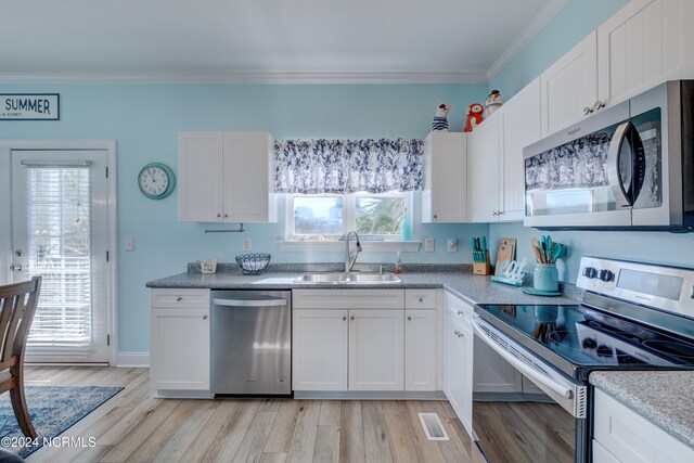 kitchen featuring light hardwood / wood-style flooring, stainless steel appliances, sink, plenty of natural light, and white cabinetry