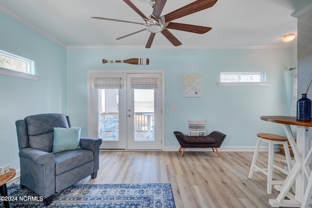 sitting room with light hardwood / wood-style flooring, french doors, a healthy amount of sunlight, and crown molding