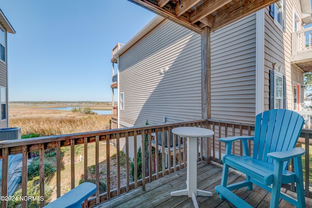 wooden terrace featuring central AC unit and a water view