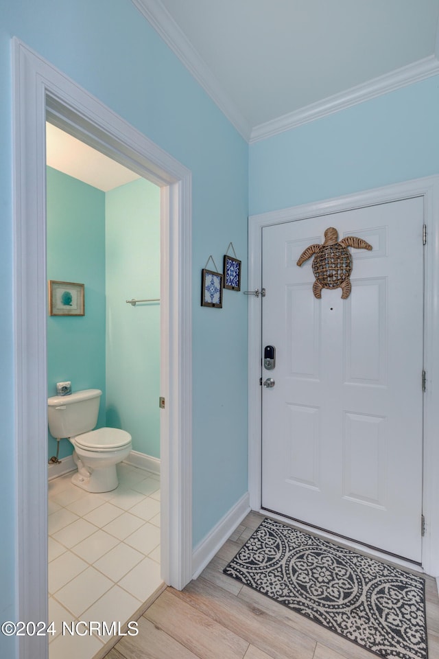 foyer entrance with crown molding and light hardwood / wood-style flooring