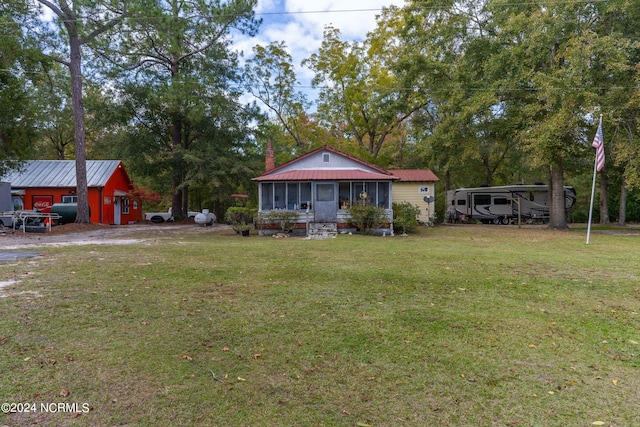 view of front of house with a carport, an outdoor structure, and a front yard