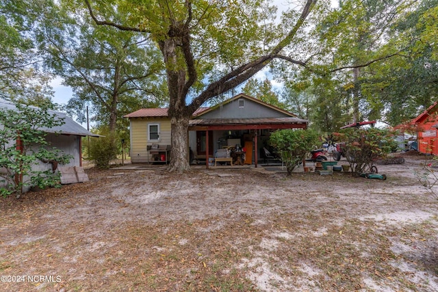 back of property featuring an outdoor structure