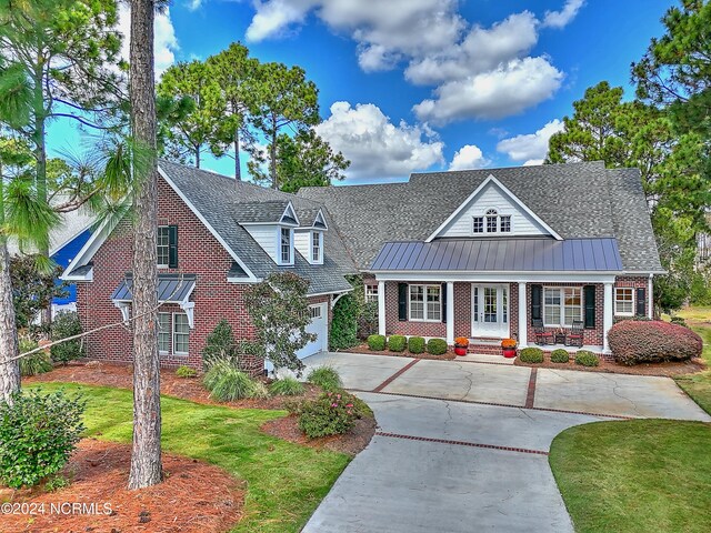 back of house featuring a lawn, a sunroom, a balcony, and a patio