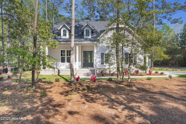 cape cod-style house featuring covered porch