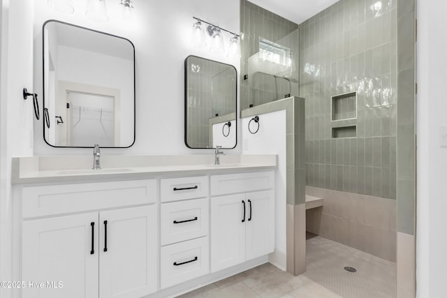full bathroom with tile patterned flooring, double vanity, a sink, and a walk in shower