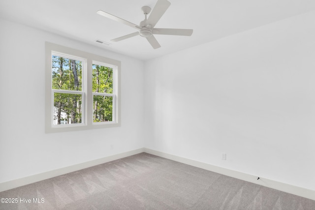 empty room featuring visible vents, carpet flooring, baseboards, and a ceiling fan
